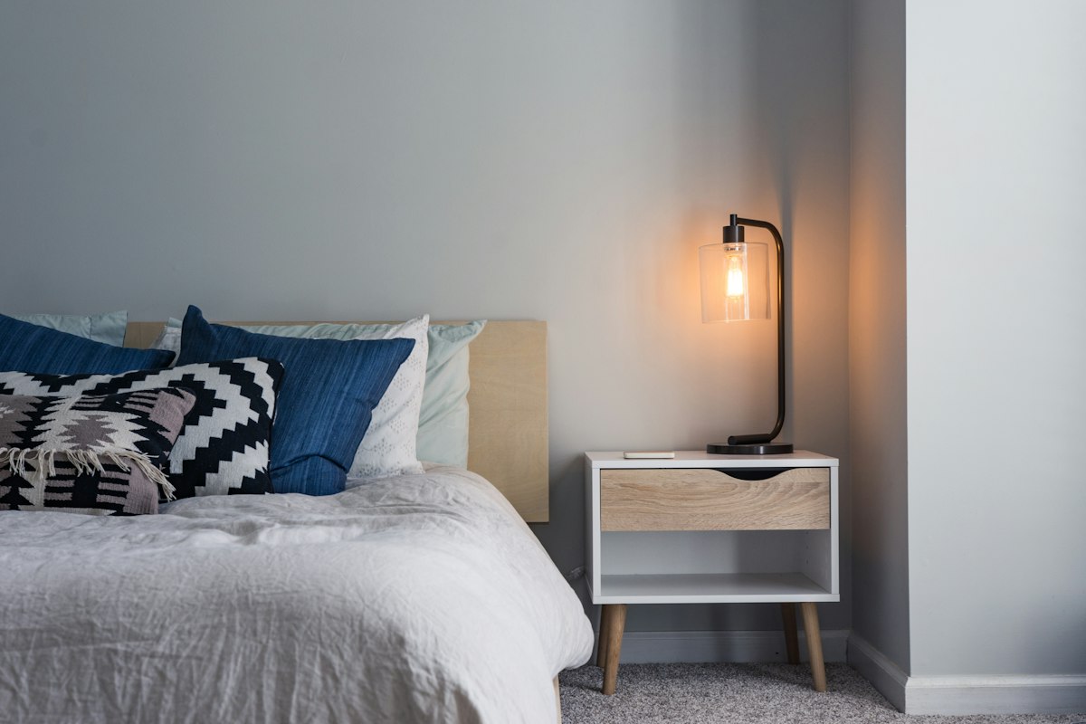 A freshly made bed in a bright bedroom